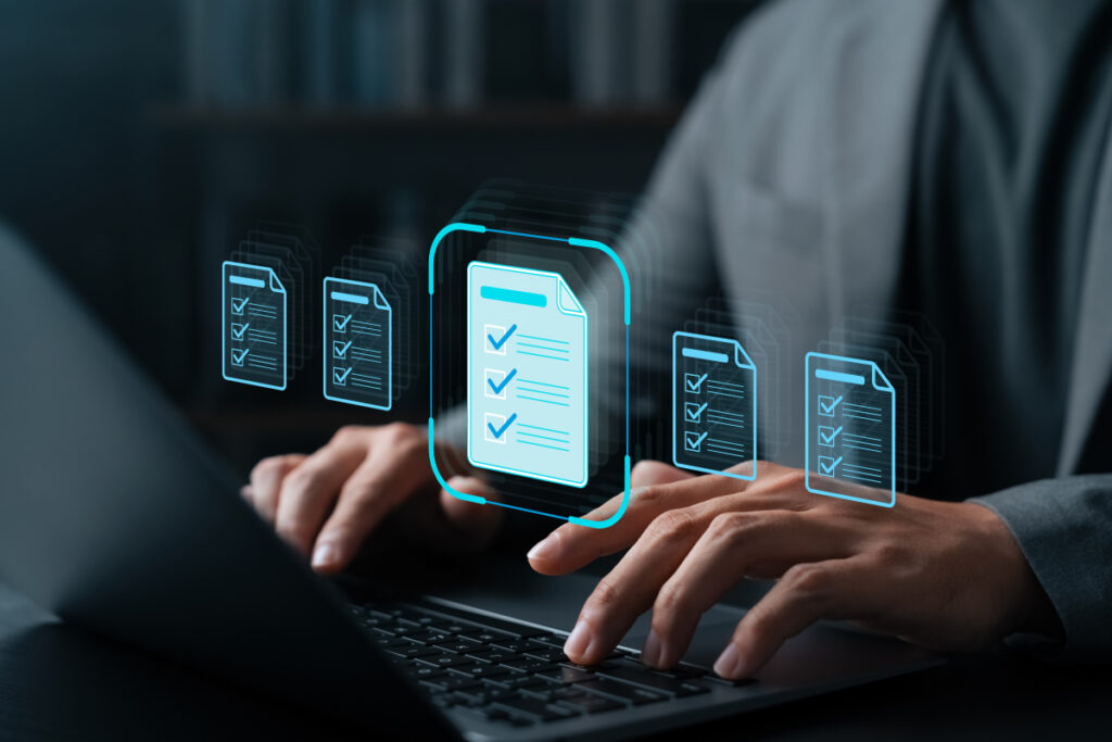 Person typing on a laptop with holographic digital document and checklist icons floating above the keyboard