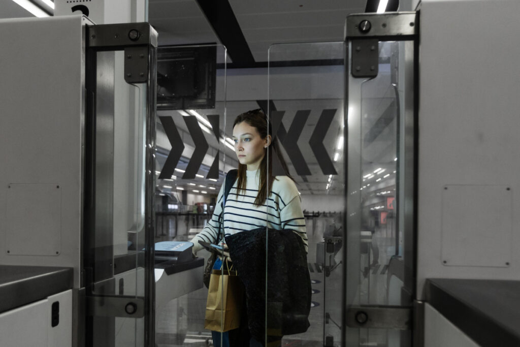Woman passing through an automated security gate or access control barrier in a public building