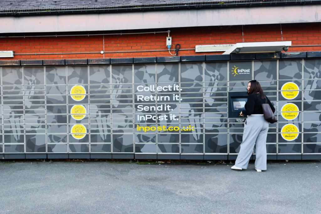 Woman using an InPost self-service parcel locker station to collect or return a delivery